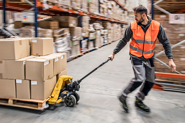 Warehouse worker pulling a crate of boxes